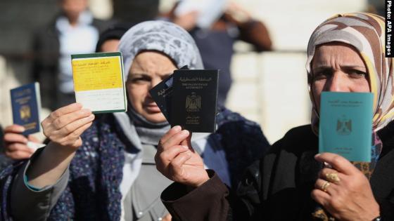 Palestinian women hold their passports during a protest demanding for the opening of Rafah crossing border in front of the headquarters of the Council of Ministers in Gaza city, on December 31, 2014. Photo by Ashraf Amra